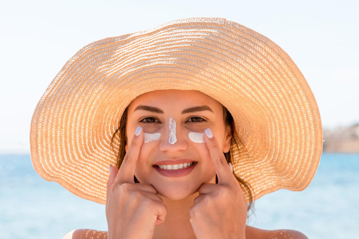 Young woman sunbathing applaying sun cream
